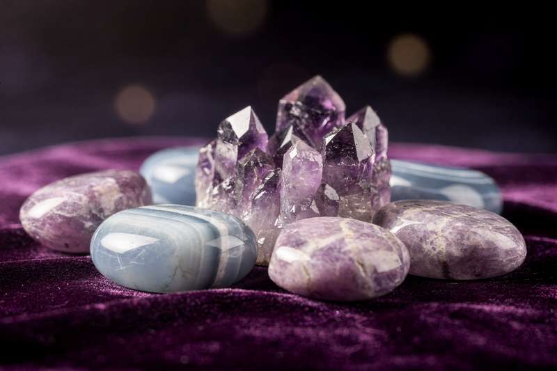 Selección de gemas y minerales translúcidos dispuestos sobre una superficie de madera natural para transmitir paz y bienestar...