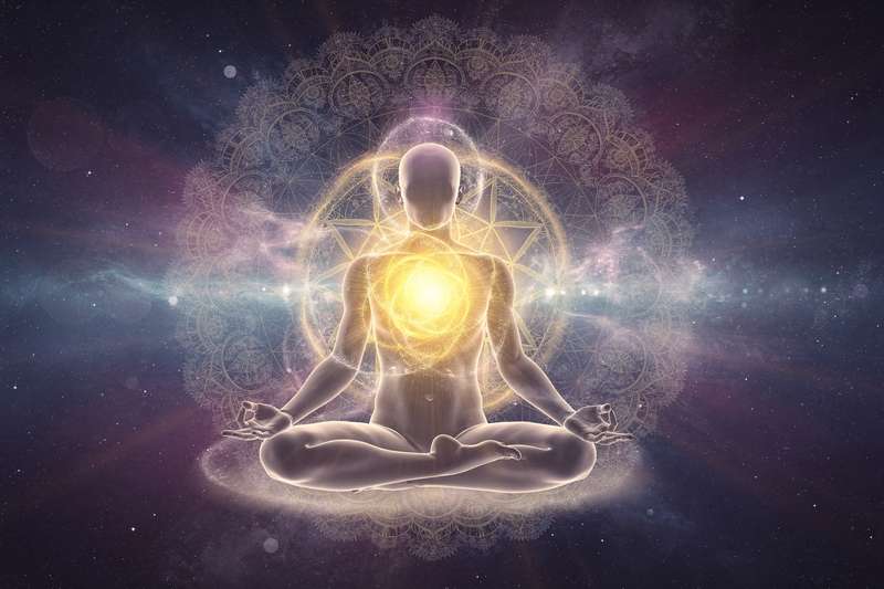 Mujer meditando con las manos sobre el abdomen para activar la energía del plexo solar y fortalecer su autoconfianza.