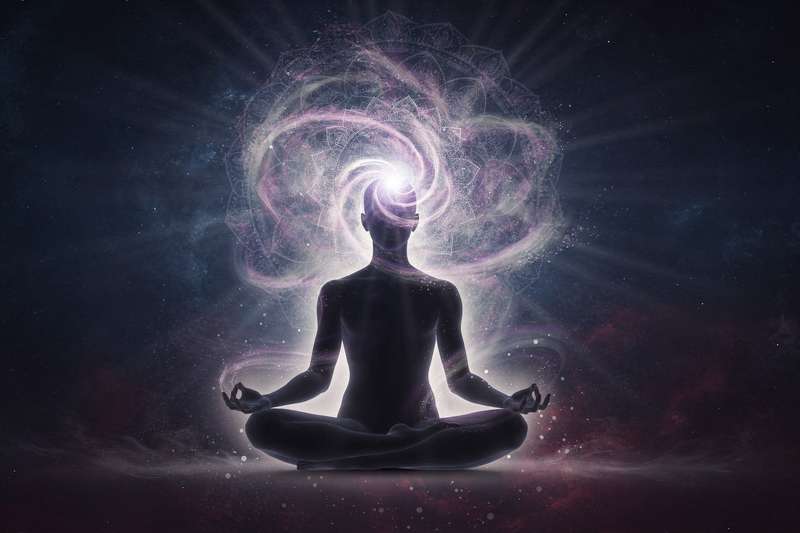 Persona meditando con luz blanca radiante sobre la coronilla en estado de conexión espiritual y elevación de conciencia.