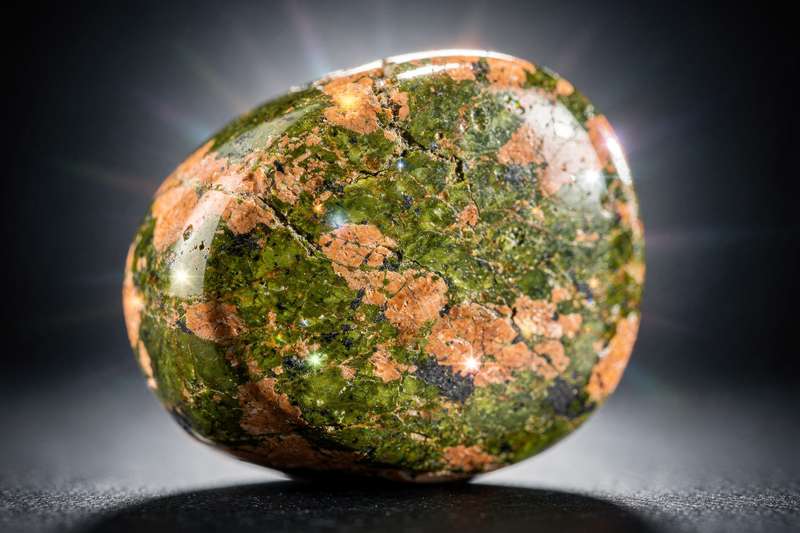 Piedra unakita con tonalidades rosadas y verdes mostrando sus características vetas naturales.