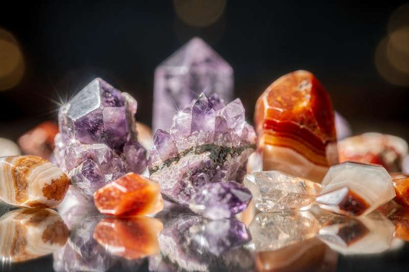 Cristales de lepidolita morada y sárdónix rojo dispuestos juntos para la protección energética del hogar.