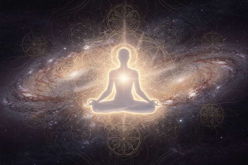 Persona meditando en paz mientras sostiene las manos abiertas hacia la luz, representando el equilibrio entre el...