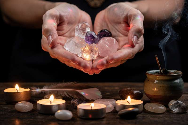 Cristales y minerales dispuestos en círculo sobre tela blanca que representan la energía femenina ancestral.
