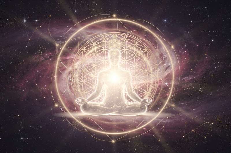 Persona meditando en posición de loto rodeada de luz dorada mientras visualiza sus metas y sueños futuros.